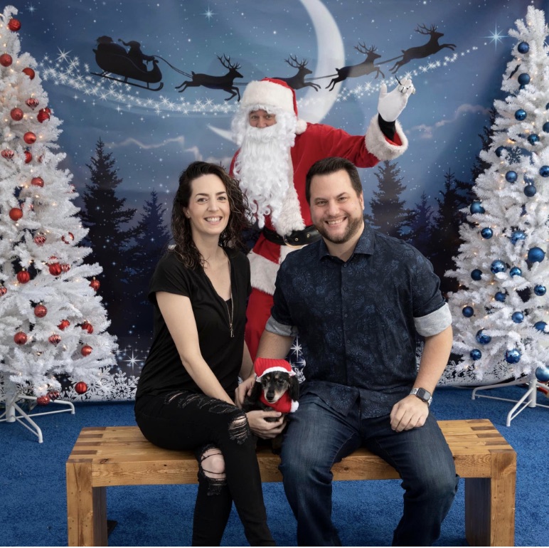 Sean with his wife and dog in front of Santa